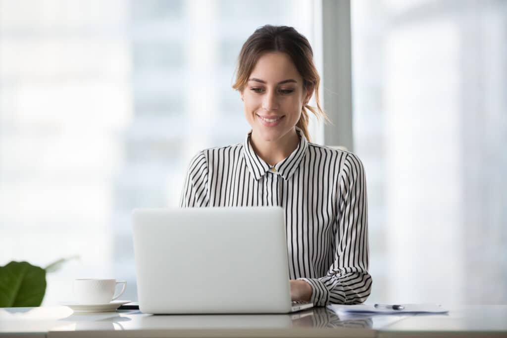 Woman working on a laptop smiling