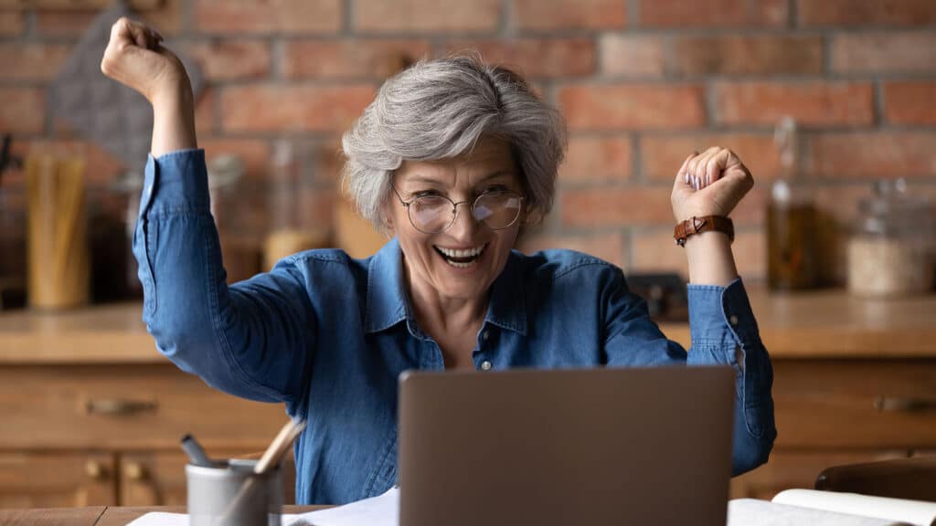 Excited mature lady scream achieving success in learning computer